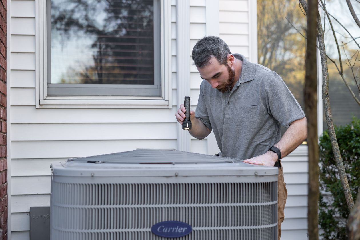 Best home warranty companies in Florida - technician inspecting a home AC unit covered under warranty