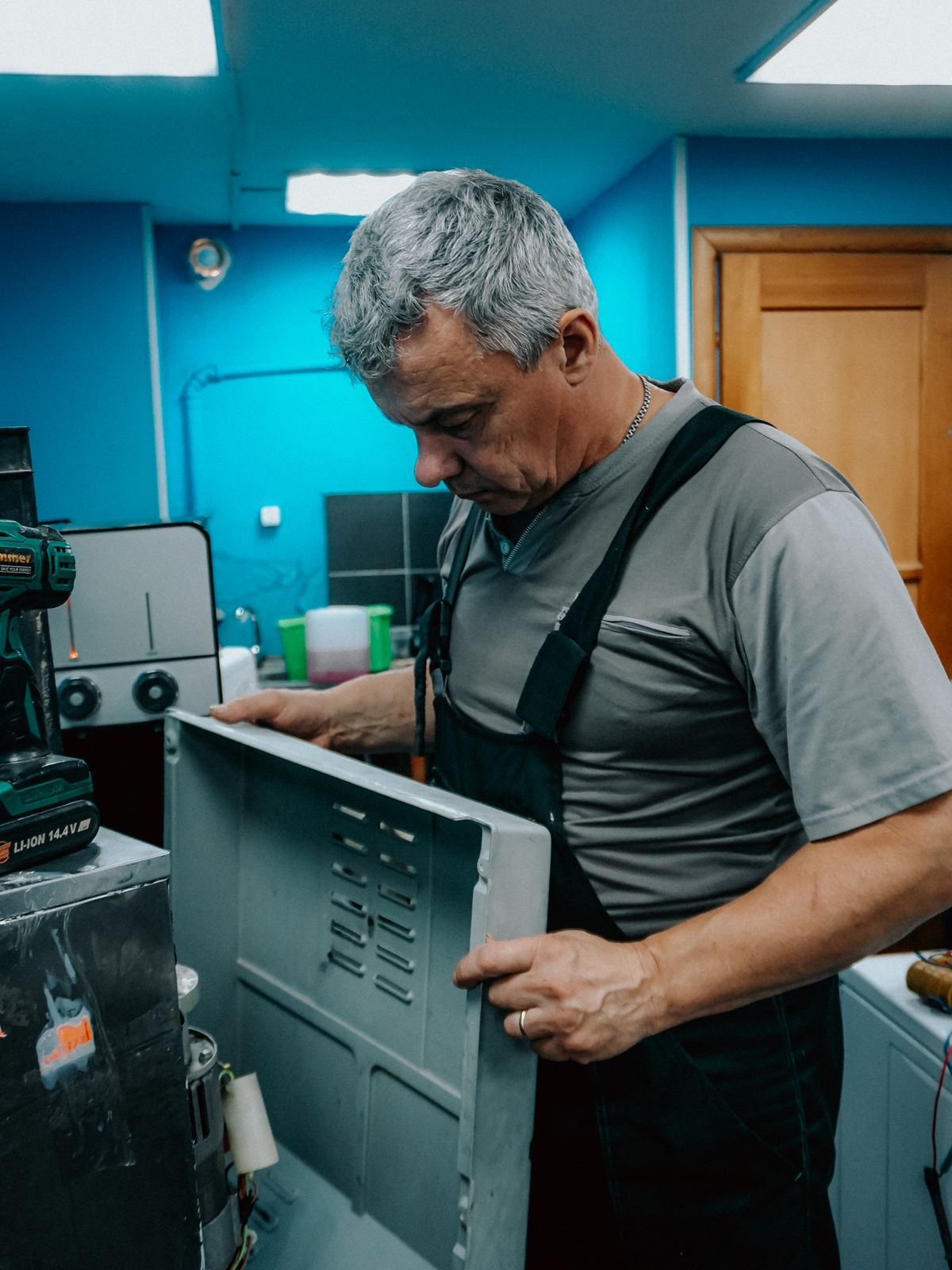 Are home warranties worth it - technician repairing a covered home appliance