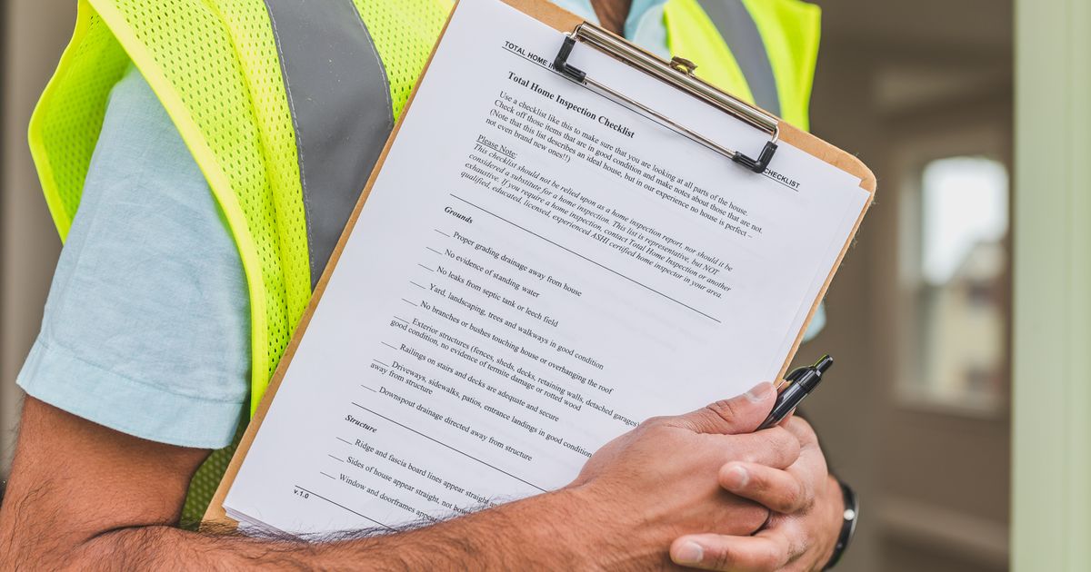 Inspector holding a home inspection checklist for a home warranty pre-existing condition claim